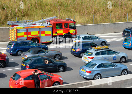 Autofahrer in massive Staus auf festgefahrene Autobahn mit Feuerwehrauto mit Standstreifen, Absturz auf einem heißen Sommertag zu erreichen Stockfoto