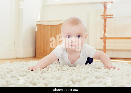 Porträt von lächelnden jungen kriechen auf Teppich Stockfoto