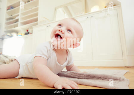 Lächelnden jungen auf Wohnzimmer Boden kriechen Stockfoto