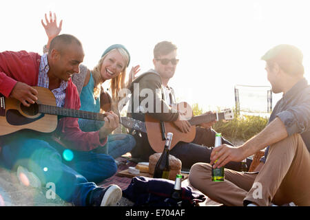 Vier Erwachsene Freunde feiern am Strand von Bournemouth, Dorset, Großbritannien Stockfoto