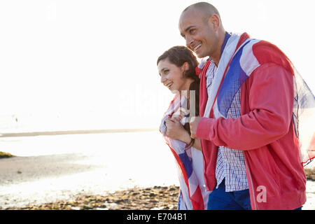 Paar verpackt in britische Flagge, ein Spaziergang am Strand von Bournemouth, Dorset, Großbritannien Stockfoto