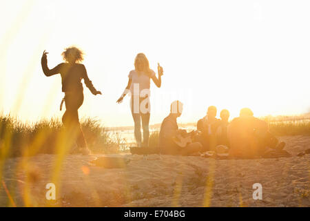 Sechs Erwachsene Freunde feiern bei Sonnenuntergang am Strand von Bournemouth, Dorset, Großbritannien Stockfoto