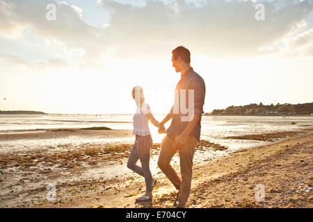 Junges Paar zu Fuß am Strand Stockfoto
