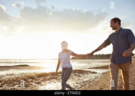 Junges Paar zu Fuß am Strand Stockfoto