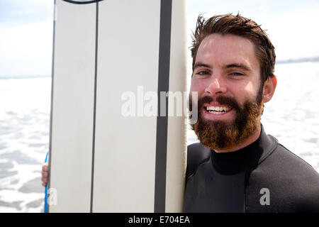 Porträt des jungen männlichen Surfer mit Surfbrett hautnah Stockfoto