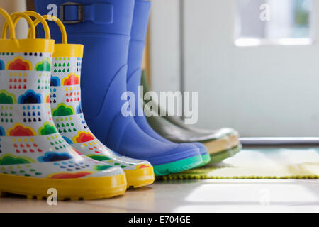 Seitenansicht der Reihe von Gummistiefeln an Hintertür hautnah Stockfoto