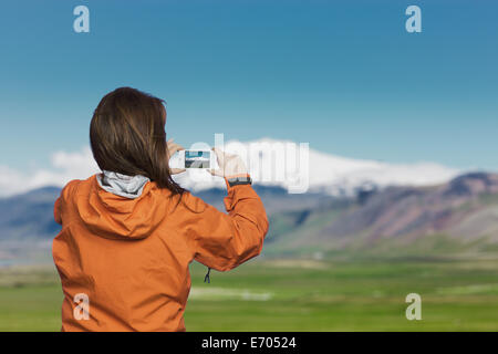 Frau unter Bild mit Smartphone Snaefellsnes Gletscher, Island Stockfoto