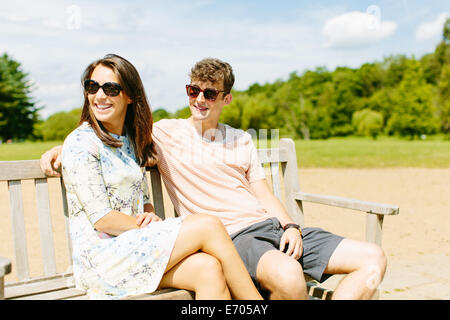Paar auf hölzerne Parkbank sitzen Stockfoto