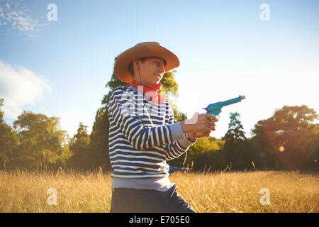 Kleiner Junge verkleidet als Cowboy, mit Spielzeugpistole Stockfoto