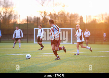 Fußball-Spieler nach dem Ball laufen Stockfoto