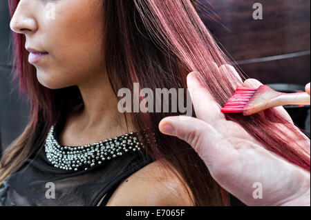 Männliche Friseur färben junge Frau Rosa Haarfarbe in Friseursalon Stockfoto