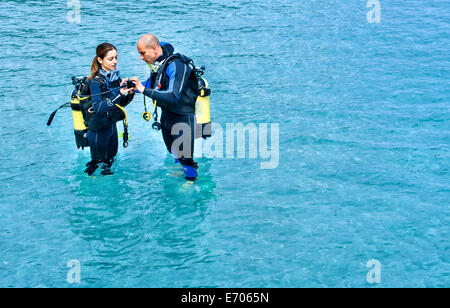 Paar Vorbereitung Scuba Tauchen im Meer, La Maddalena, Sardinien, Italien Stockfoto