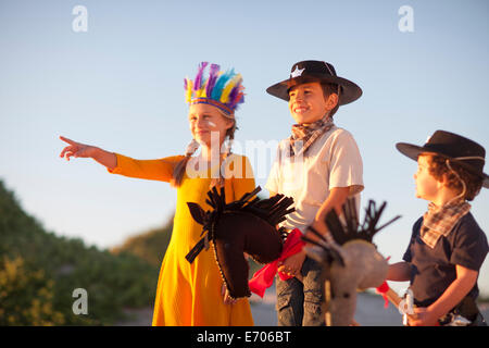 Drei Kinder, verkleidet als Indianer und Cowboys aus Sanddünen Stockfoto