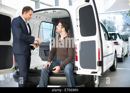 Unentschlossenen Kunden und Verkäufer im Autohaus Stockfoto