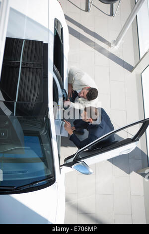 Draufsicht der Verkäufer und Kunde Inspektion Neuwagen im Autohaus Stockfoto