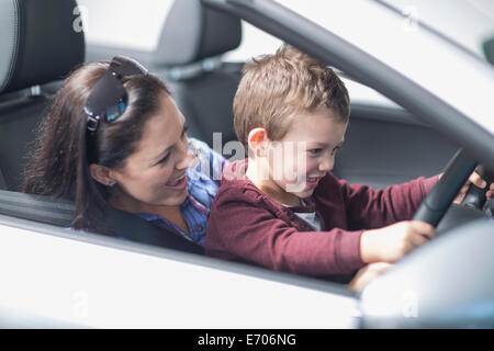 Mutter und Sohn ausprobieren Neuwagen im Autohaus Stockfoto