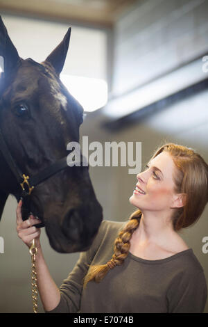 Porträt von weiblichen Stallknecht mit Pferd im Stall Stockfoto