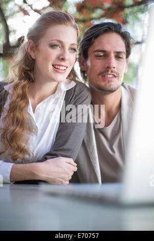 Geschäftsmann und Frau Kollegin Blick auf Computer bei informellen Treffen im Garten Stockfoto
