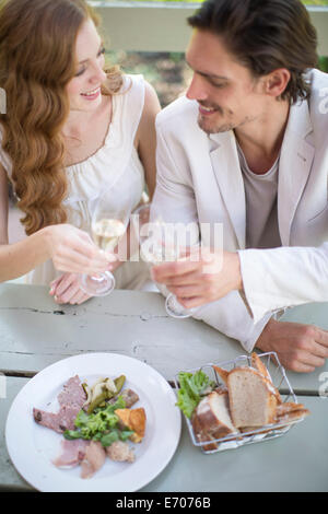 Paar, toasten mit Champagner am Tisch im Garten-restaurant Stockfoto