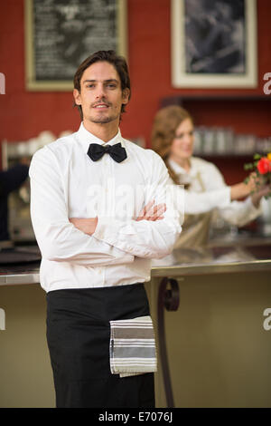 Porträt der Kellner mit im Restaurant verschränkten Armen Stockfoto