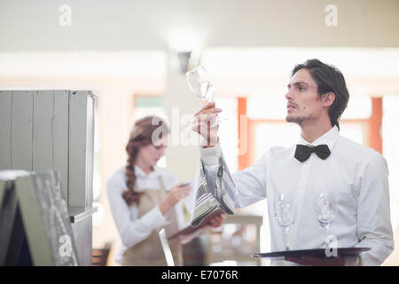 Kellner hochhalten und Überprüfung Glas Wein im restaurant Stockfoto