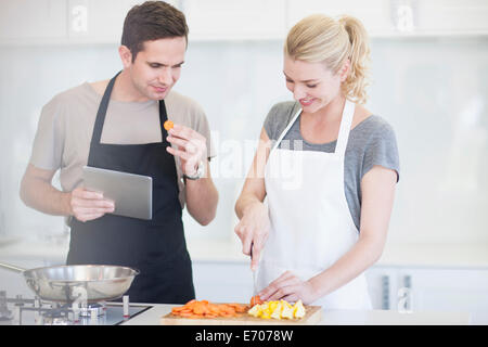 Paar hacken und Verkostung in Scheiben geschnittene Gemüse in der Küche Stockfoto