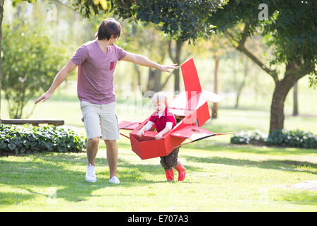 Vater und Sohn läuft mit Spielzeugflugzeug im park Stockfoto