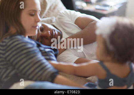 Mutter und Vater mit Tochter am Bett liegen Stockfoto