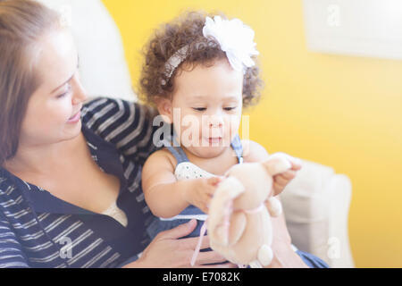 Mutter Baby Tochter hielt, mit Spielzeug spielen Stockfoto