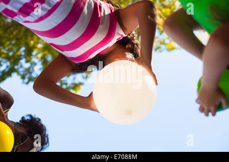 Niedrigen Winkel Ansicht von drei Mädchen Aufblasen des Ballons im Garten Stockfoto