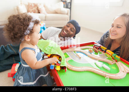 Mutter und Vater mit Tochter, Zug am Tisch spielen Stockfoto