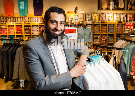 Porträt von Schneider gelehnt Schienen in Herren Kleidung shop Stockfoto