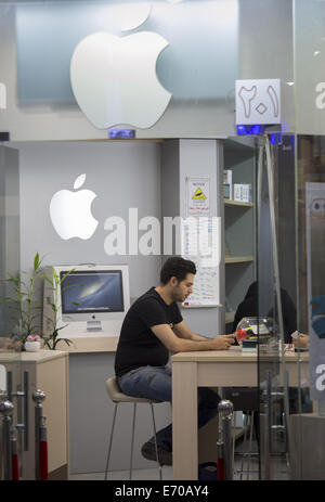 Teheran, Iran. 2. Sep, 2014. 2. September 2014 - Teheran - eine iranische Händler sitzt eine gefälschte Apple speichern in Teherans Paytakht (Hauptstadt) Rechenzentrum. Morteza Nikoubazl/ZUMAPRESS © Morteza Nikoubazl/ZUMA Draht/Alamy Live-Nachrichten Stockfoto