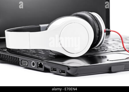 Nahaufnahme von Kopfhörern auf einem Laptop, auf weißem Hintergrund. Stockfoto