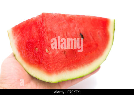 Hand, die ein Stück Wassermelone auf weißem Hintergrund Stockfoto
