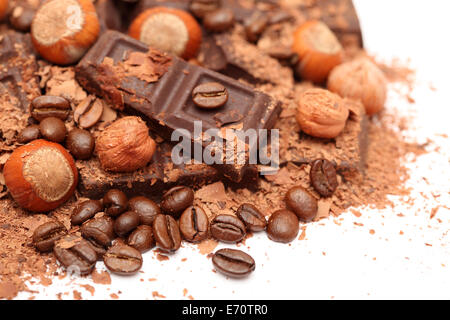Schokolade, Haselnüsse und Kaffeebohnen auf weißem Hintergrund. Closeup. Stockfoto
