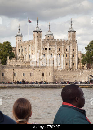 der Tower of London und Verräter Tor aus einem Ausflugsboot auf der Themse mit Touristen im Vordergrund angezeigt Stockfoto