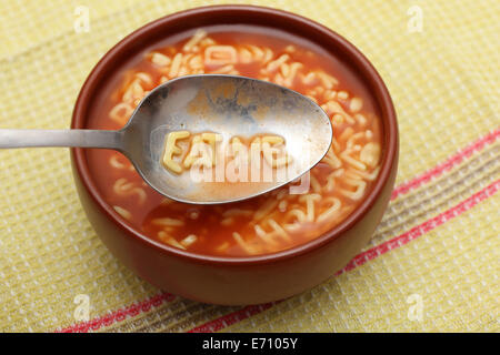 Alphabet Buchstaben in Löffel buchstabieren "Eat me". Alphabet Soup Nudeln in eine Schüssel geben. Closeup. Stockfoto