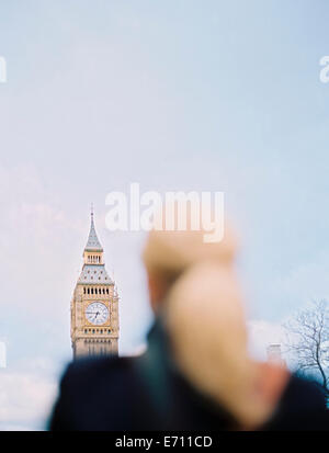 Eine Frau blickte zu Big Ben, The Elizabeth Tower in den Houses of Parliament in London. Stockfoto