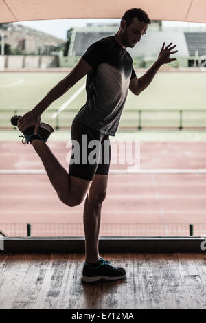 Mitte erwachsenen Mannes Beinmuskulatur dehnen Stockfoto