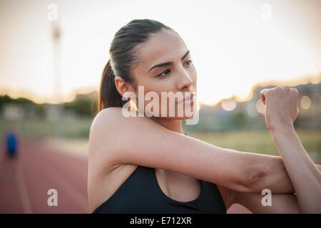 Junge Frau stretching arm Stockfoto