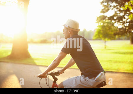 Mitte erwachsener Mann Reiten Fahrrad im sonnigen park Stockfoto