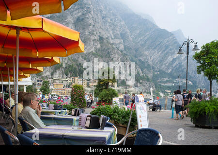 Urlauber, Essen im Freien vor einem Restaurant in der malerischen Ortschaft Limone am Ufer des Gardasee, Italien. Stockfoto