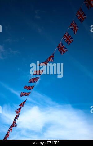 Zeile des Union Jack-Flaggen vor blauem Himmel Stockfoto