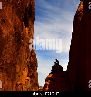 Silhouette der Frau sitzt auf Stein im Rock Canyon im Arches National Park Stockfoto