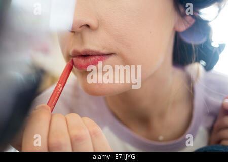 Junge Erwachsene setzen auf Make-up im Spiegel. Stockfoto
