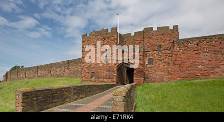 Historischen Carlisle Castle mit imposanten roten Sandsteinmauern und Eingang mit Fallgatter, umgeben von grünen Graben Stockfoto