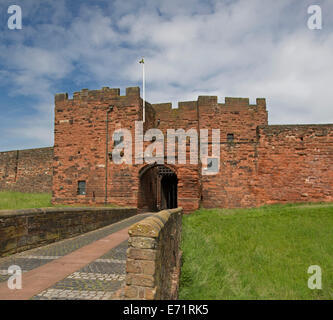 Historischen Carlisle Castle mit imposanten roten Sandsteinmauern und Eingang mit Fallgatter, umgeben von grünen Rasen Stockfoto