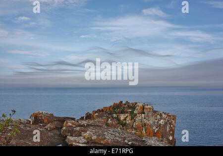 Schöne, wispy Wolken über einem Felsvorsprung am Lake Superior. Stockfoto