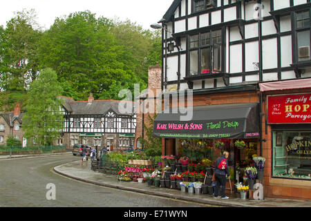 Hauptstraße und Blumenladen mit Frau bewundern bunte Fußweg anzeigen im malerischen Dorf von Lymm in Cheshire, England Stockfoto